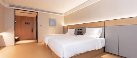 A hotel room with a double bed, a bedside table, a wardrobe, and a door leading to a hallway.