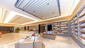 A modern interior with a reception desk, bookshelves, and a seating area. - Ji Hotel (Nanjing)