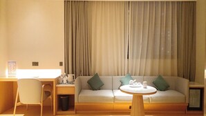 Una sala de estar moderna con un sofá, una mesa de centro y un escritorio con una silla.