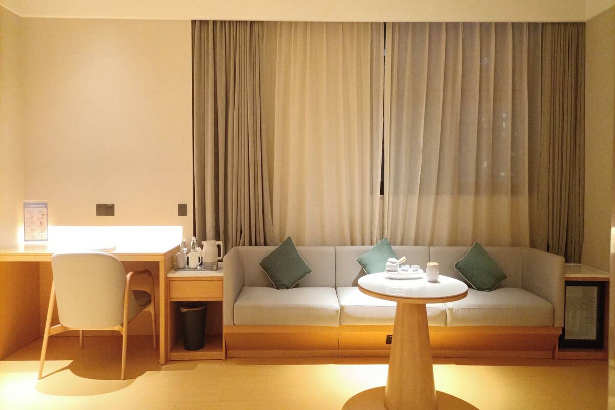 Ein modernes Wohnzimmer mit einer Couch, einem Couchtisch und einem Schreibtisch mit Stuhl.