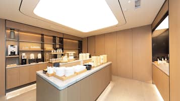 A modern kitchen with a central island, built-in appliances, and a large skylight.