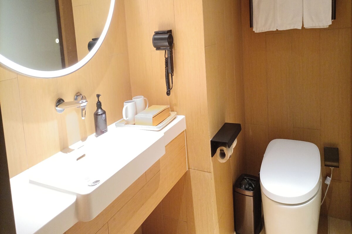 A bathroom with a sink, mirror, towel rack, and toilet.