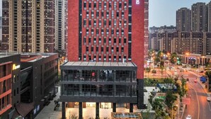 Un edificio moderno con fachada roja y un amplio acceso de vidrio.