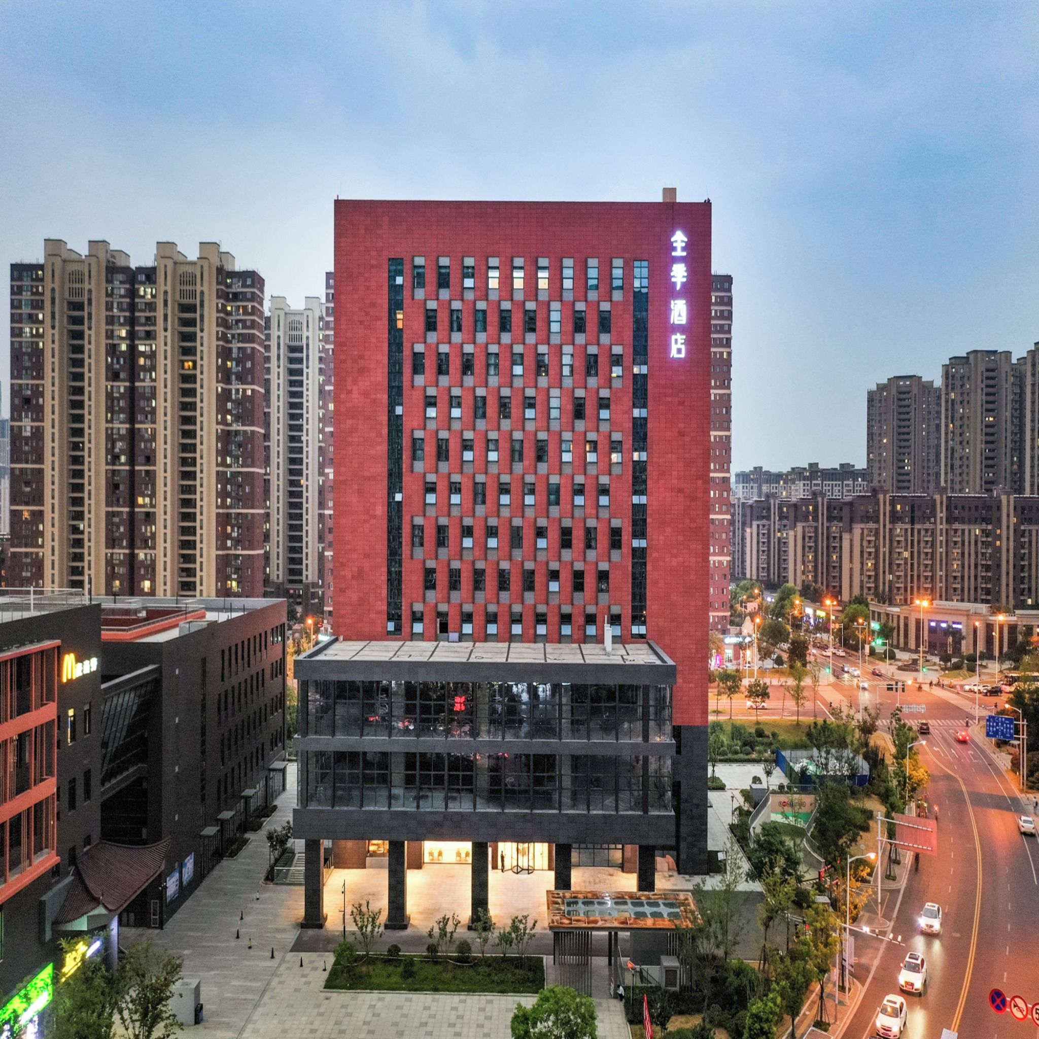 Un edificio moderno con fachada roja y un amplio acceso de vidrio.