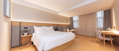 A modern hotel room with a large bed, bedside tables, a desk, and a chair.