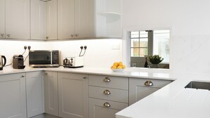 A modern kitchen with white cabinets, a microwave, a toaster, and a bowl of lemons on the counter. - 4 bedroom accommodation in Middleton-on-Sea, near Bognor Regis (Middleton-on-Sea, near Bognor Regis)