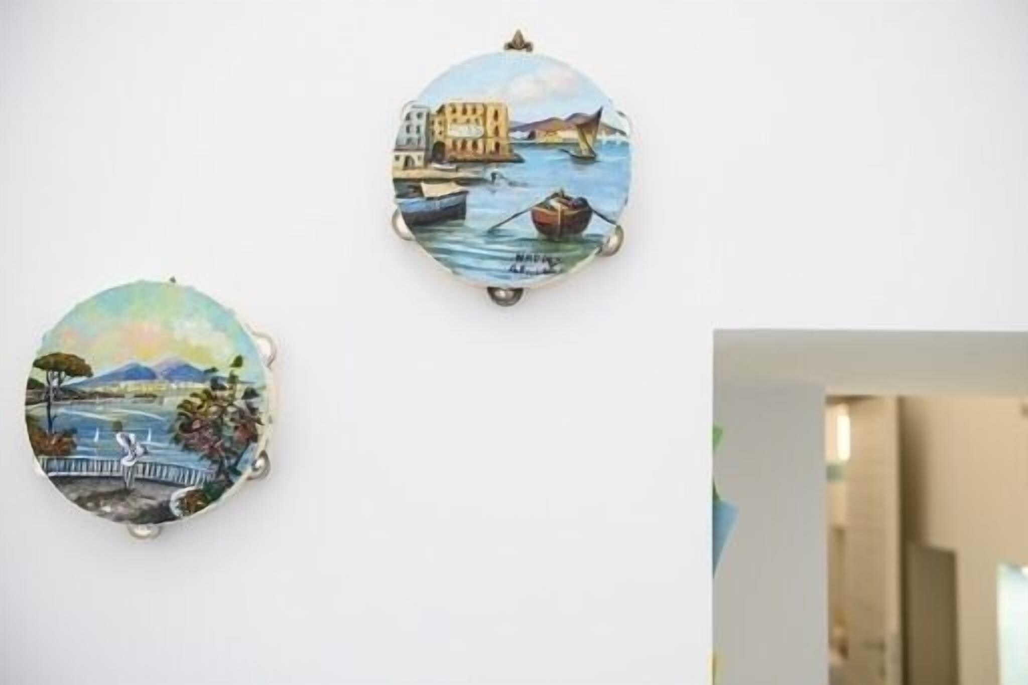 Zwei runde Wandbilder mit Küstenmotiven.