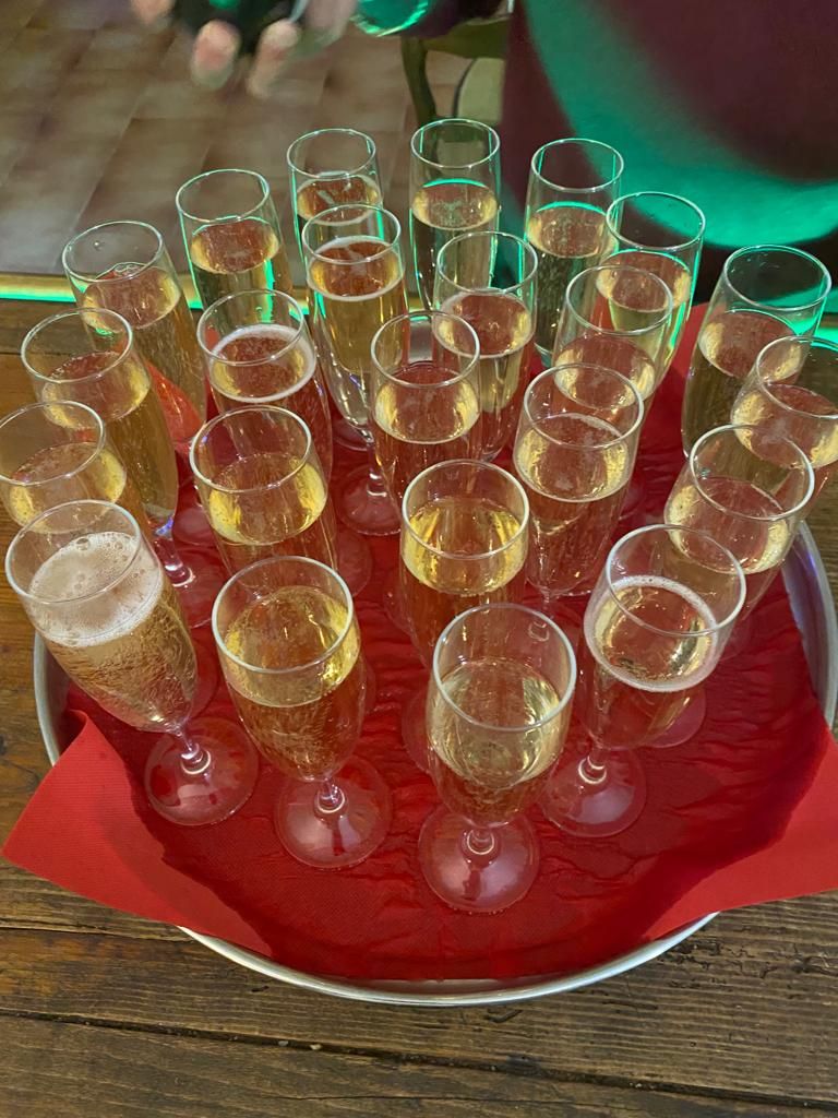 Ein Tablett mit Champagnergläsern auf rotem Stoff.