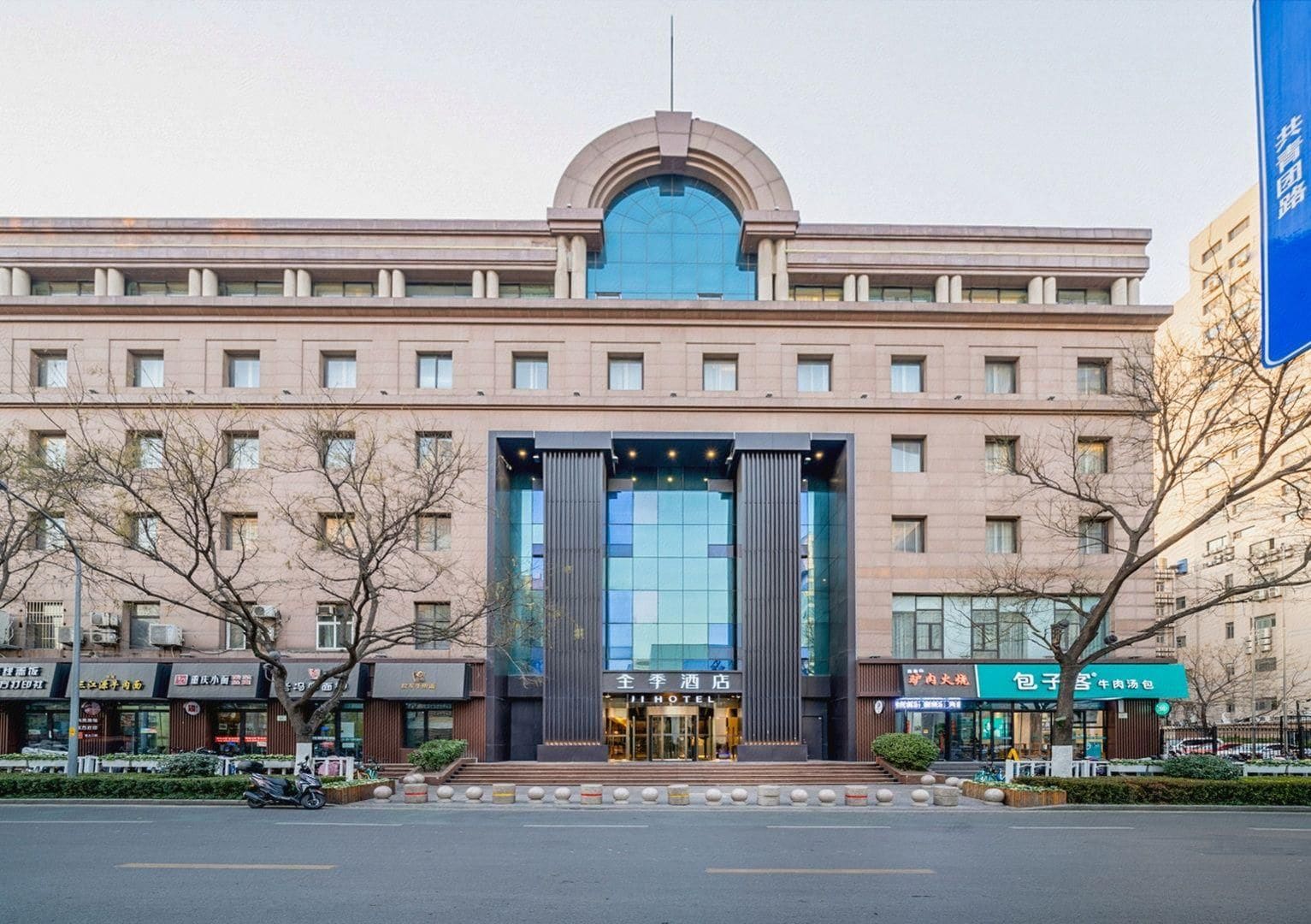 A hotel with a prominent entrance, multiple floors, and a large glass facade.