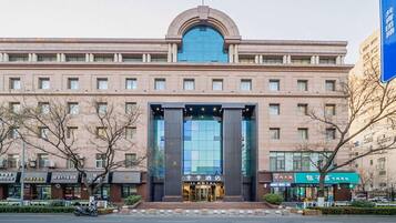 A hotel with a prominent entrance, multiple floors, and a large glass facade.