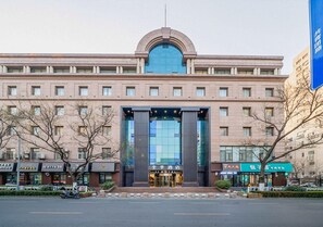 A hotel with a prominent entrance, multiple floors, and a large glass facade. - Ji Hotel (Jinan)