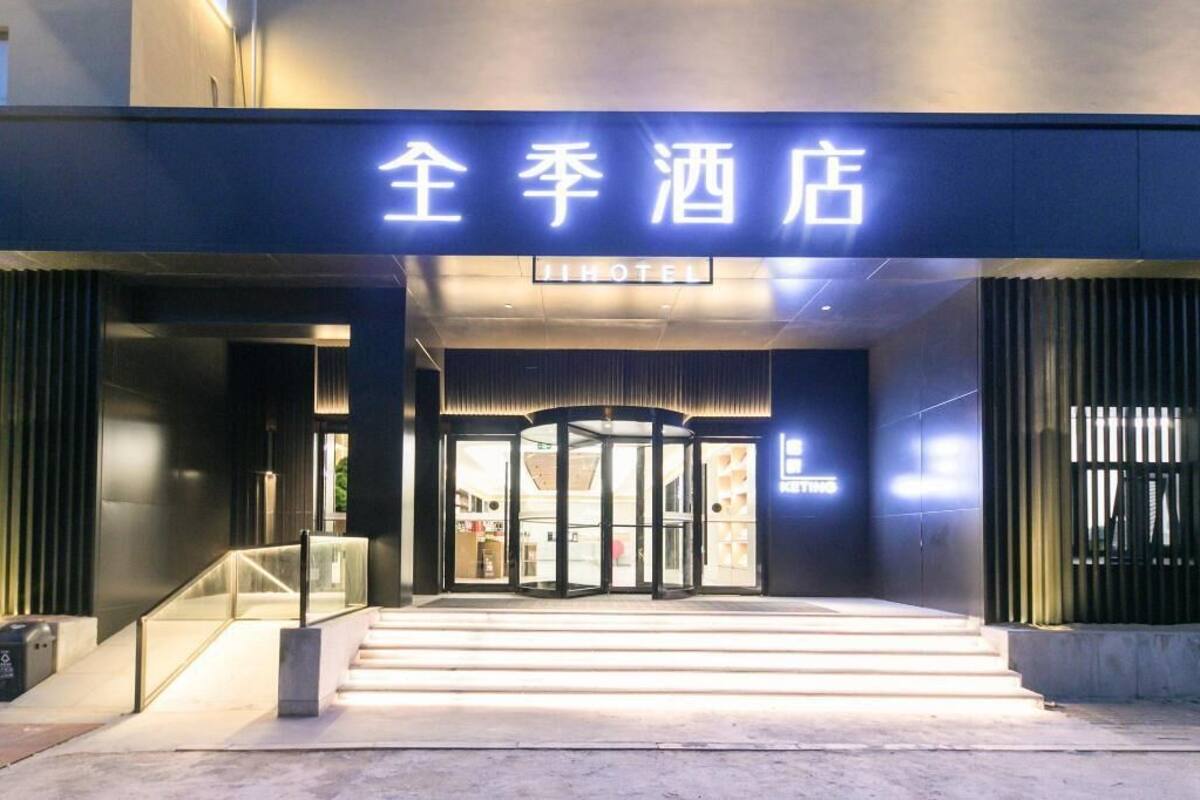 A hotel entrance with a revolving door and a sign above it.