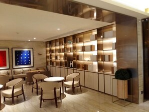 A modern interior with a seating area, a wall-mounted display, and a potted plant. - Ji Hotel (Jinan)