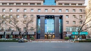 Hotel con fachada moderna, amplio acceso de vidrio y diseño simétrico.
