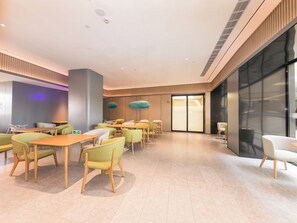 A modern hotel lobby with a seating area, a reception desk, and a large glass wall. - JI Hotel (Hangzhou)
