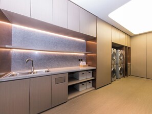 A modern kitchen with a built-in sink, cabinets, and a countertop. - JI Hotel (Hangzhou)