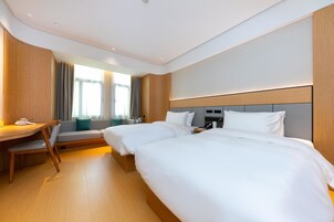 Una habitación de hotel con dos camas, un escritorio y una silla.