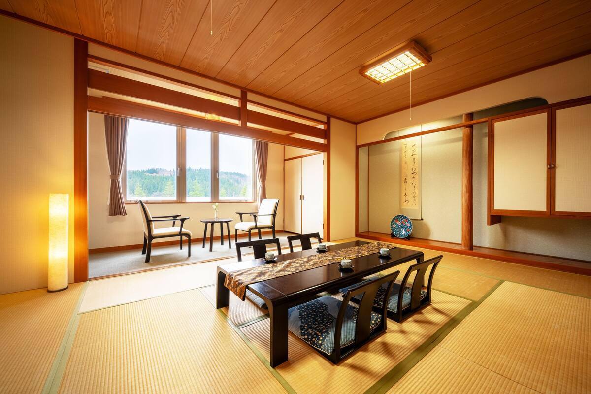 Una habitación de estilo japonés tradicional con suelo de tatami, una mesa de madera baja y puertas correderas shoji.