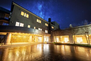Un edificio moderno con una entrada amplia y un cielo nocturno estrellado.