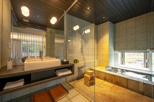 Un baño moderno con un espejo grande, una bañera y una ducha.