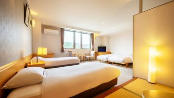 A hotel room with two beds, a TV, a desk, and a window with curtains.