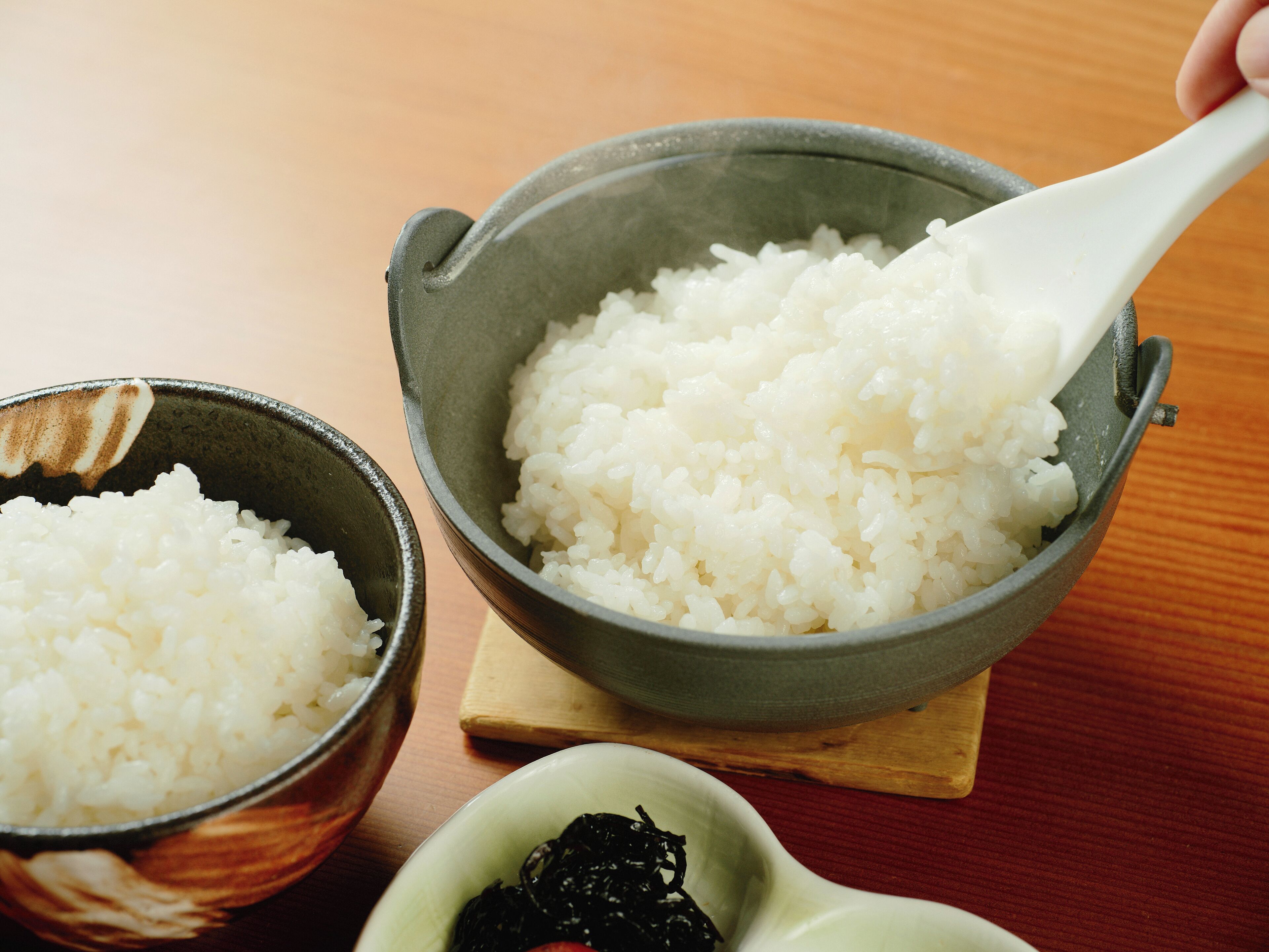 Dos tazones de arroz blanco sobre una mesa de madera.