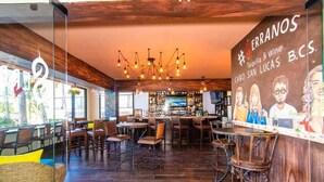 L’intérieur d’un restaurant, avec un plancher en bois, un bar et différents types de sièges.