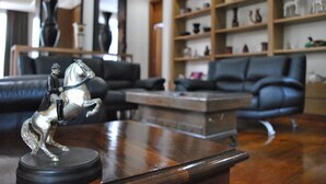 A living room with a coffee table, a sofa, and a bookshelf. - DDM Siam Thailand (Bang Lamung)