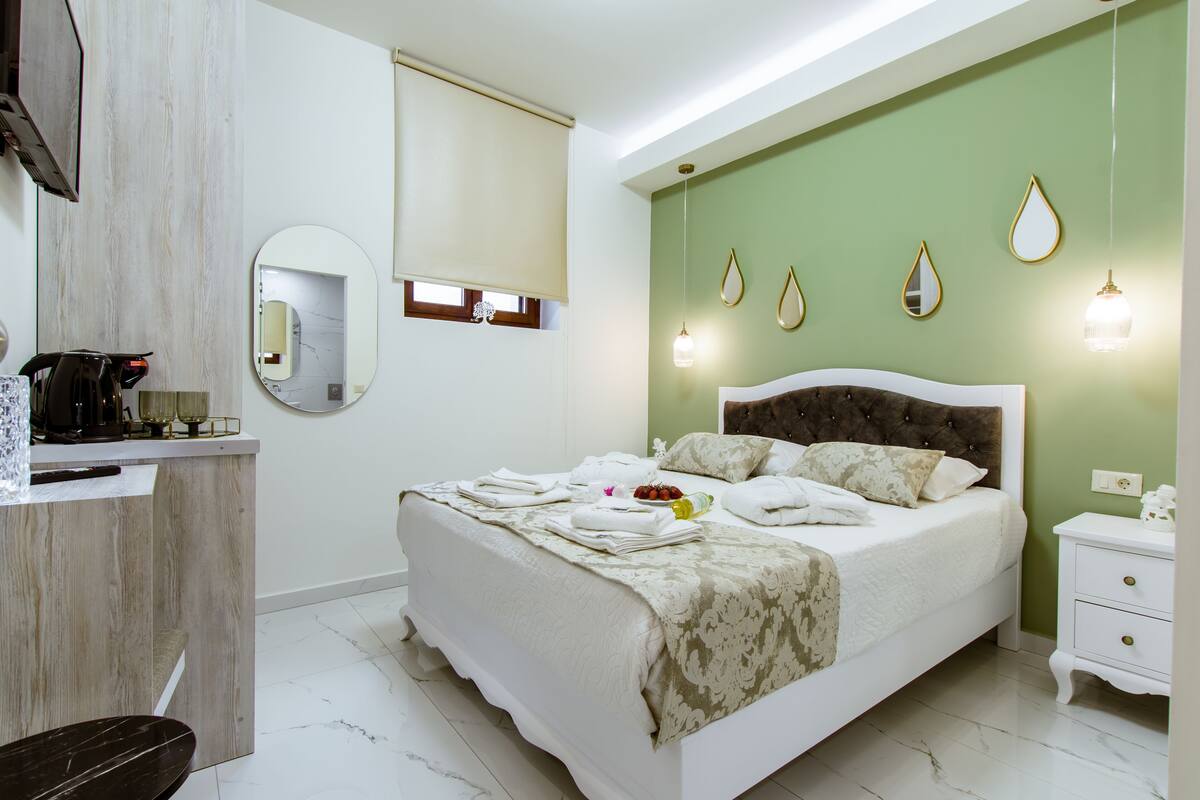 Une chambre à coucher avec un lit, une table de chevet et un miroir.