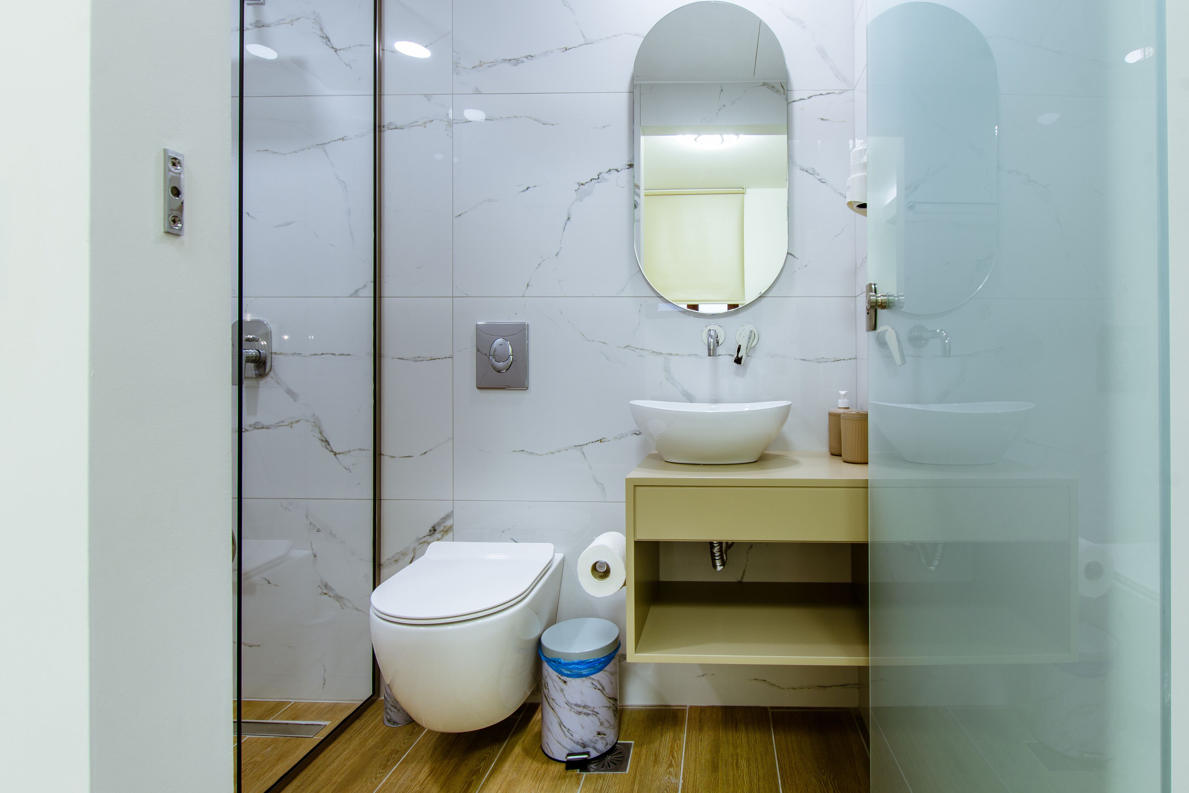 Un baño moderno con inodoro, lavabo y espejo.