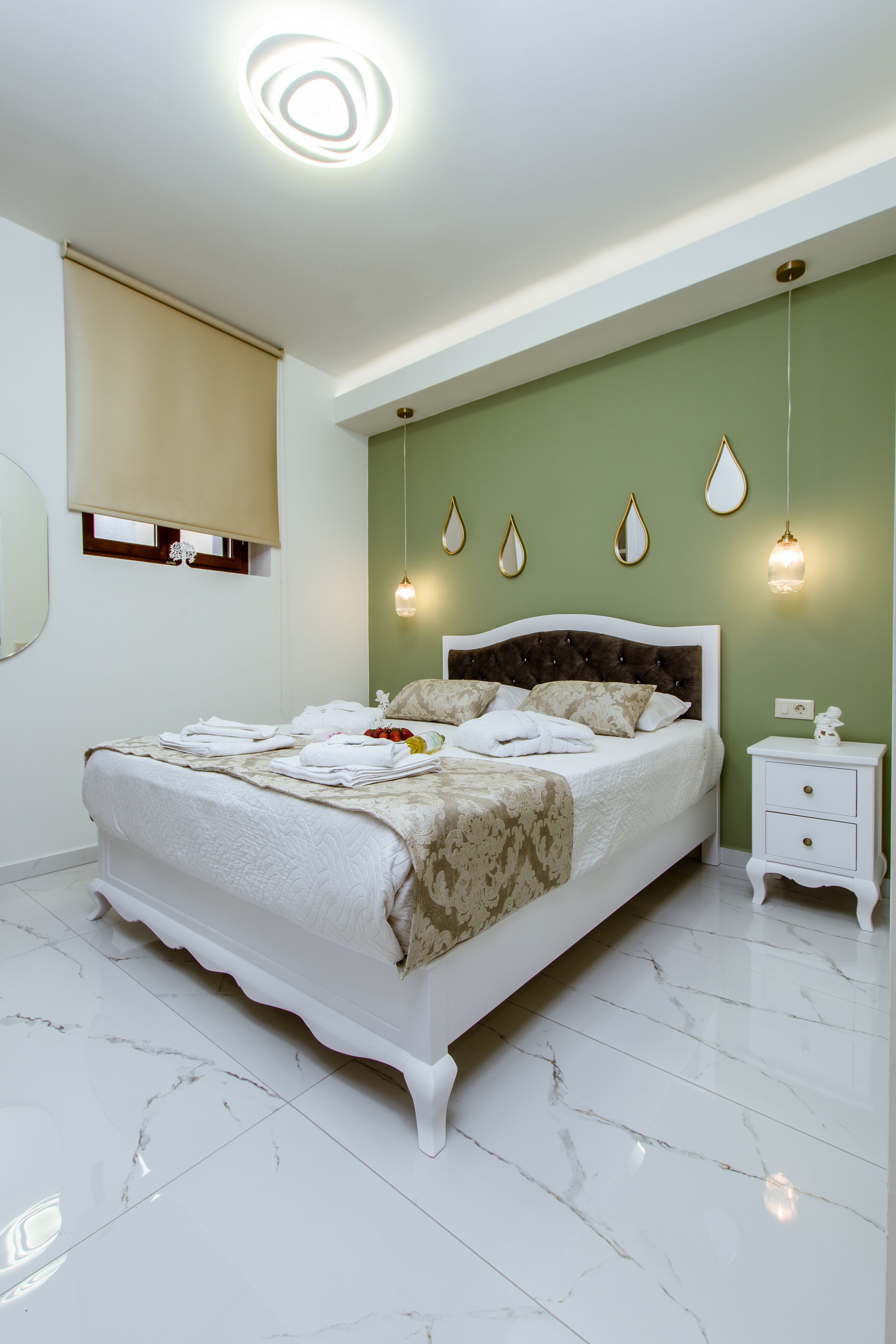 A bedroom with a bed, bedside table, and wall-mounted light fixtures.