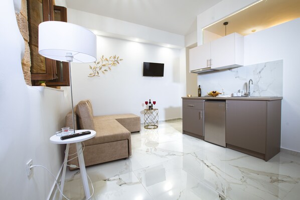 A modern kitchen with marble countertops, a built-in oven, and a stainless steel sink.