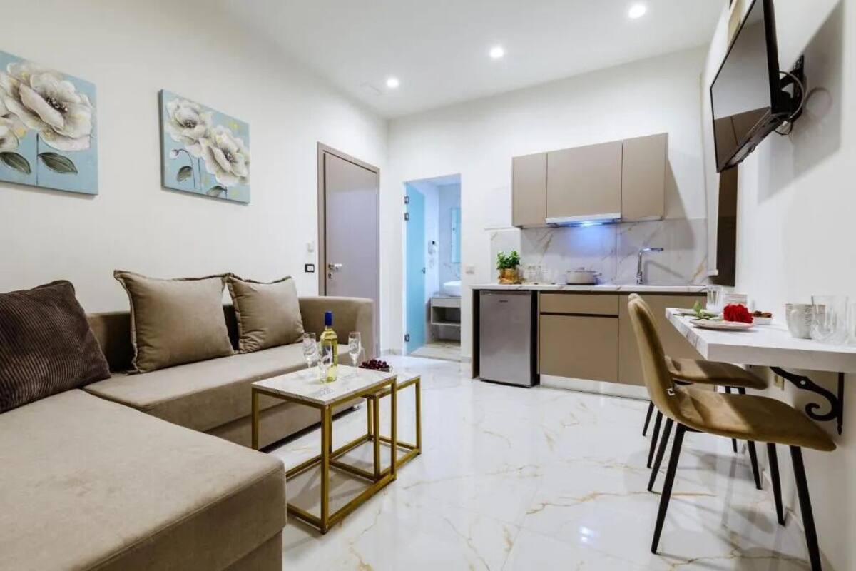 Un salon moderne comprenant un canapé, une table basse et un coin repas avec des chaises.