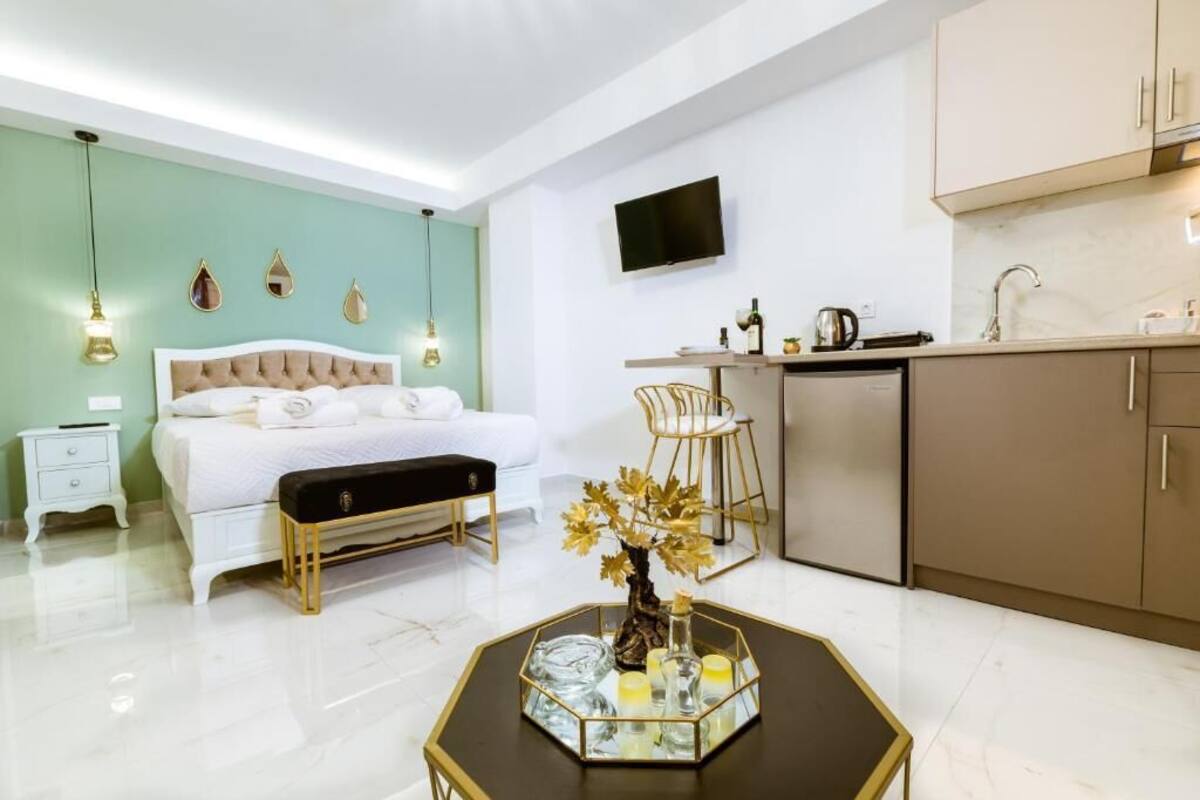 Une chambre d’hôtel moderne équipée d’un lit, d’une table de chevet et d’une petite kitchenette.