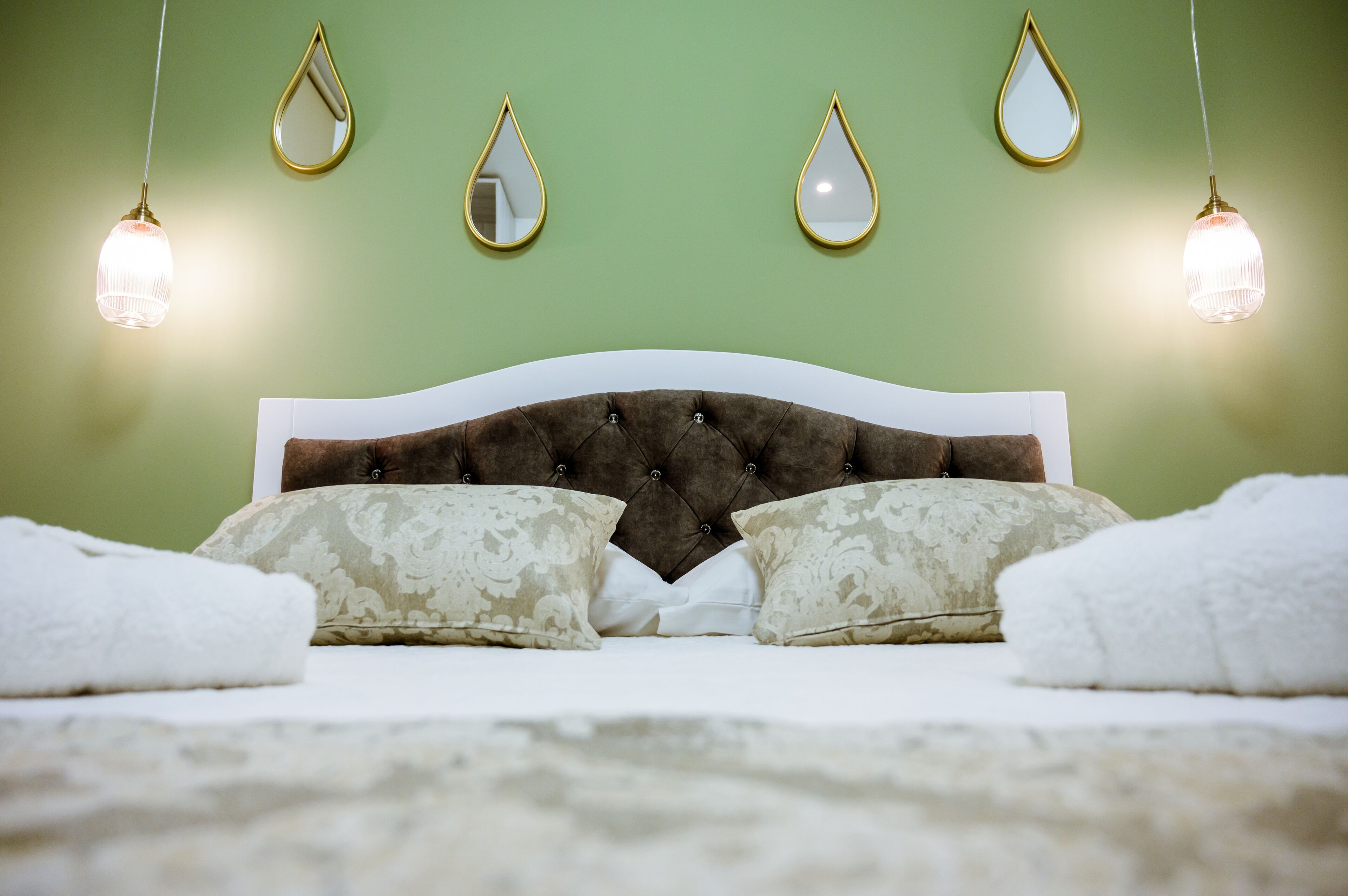 Ein Bett mit einer karrierten Kopfteil, zwei Zierkissen und zwei Nachttischlampen.