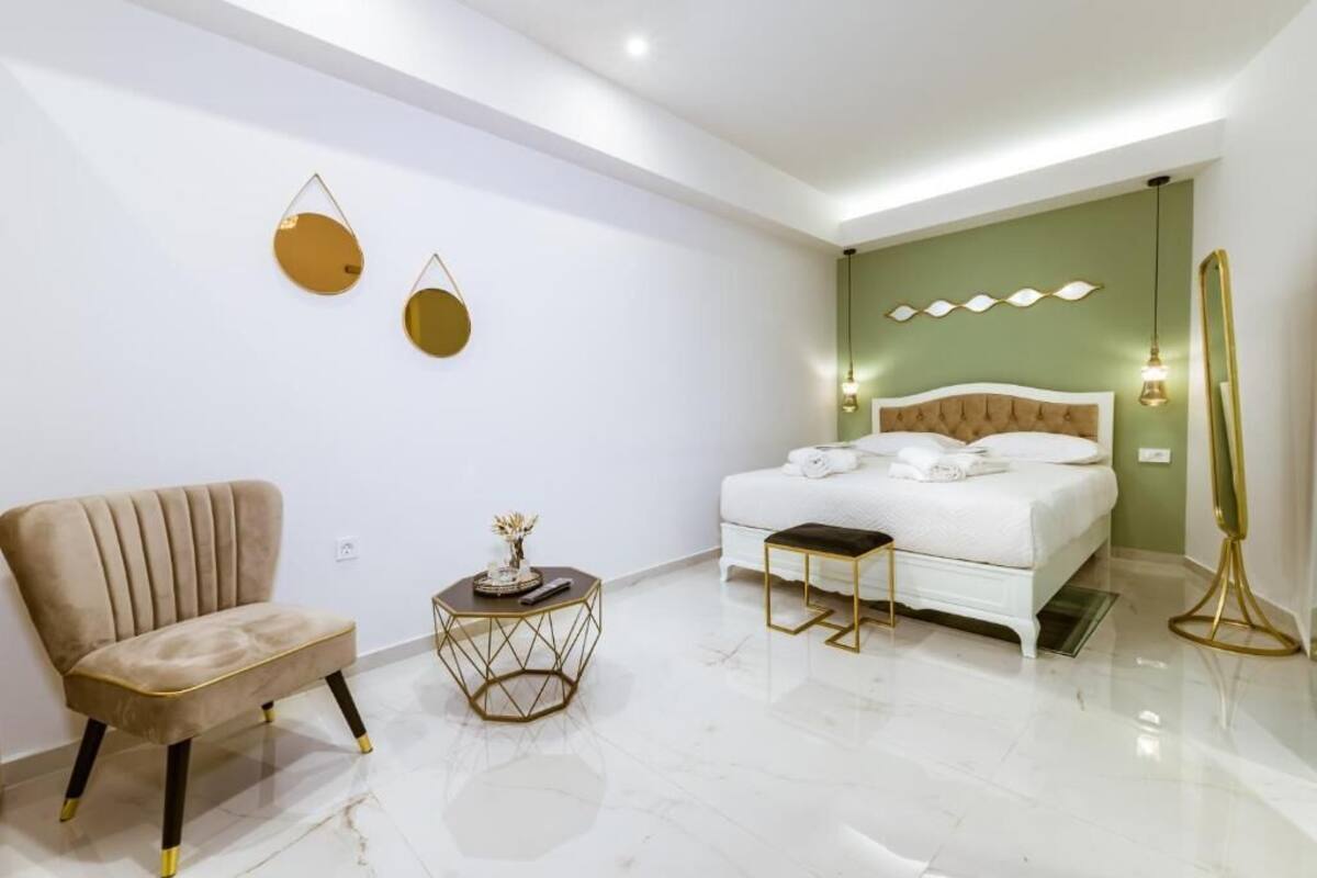Une chambre moderne comprenant un lit, une chaise, une table de chevet et des œuvres d’art décoratives au mur.