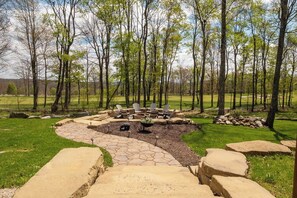 A stone pathway leading to a fire pit area with outdoor seating. - A Lil Slice of Heaven by Taylor Made Deep Creek (McHenry)