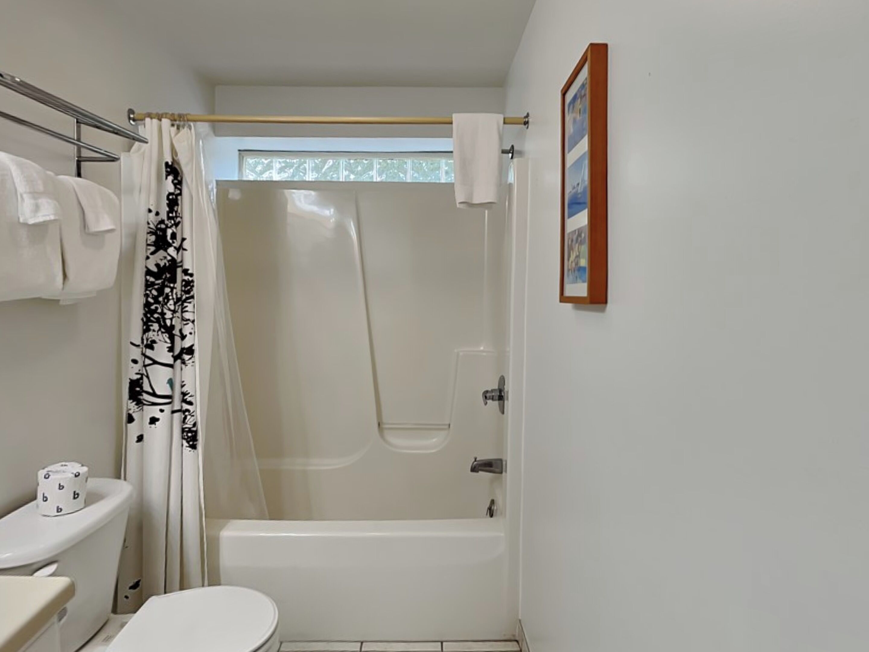 A small, clean bathroom with a toilet, sink, and bathtub.