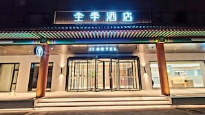 A hotel entrance with a traditional Asian architectural style, featuring a signboard with Chinese characters and a modern "HOTEL" sign above the entrance. - Ji Hotel (Beijing)