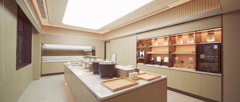 A modern kitchen with a central island, built-in appliances, and a large skylight.