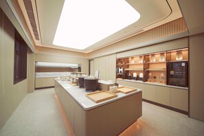 Una cocina moderna con una isla central, electrodomésticos integrados y un tragaluz grande.