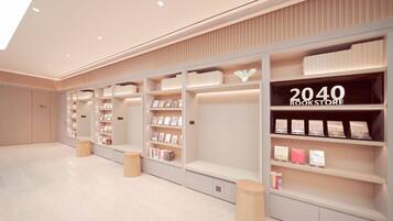 A modern bookstore interior with white shelving, books, and a '2040 BOOKSTORE' sign.