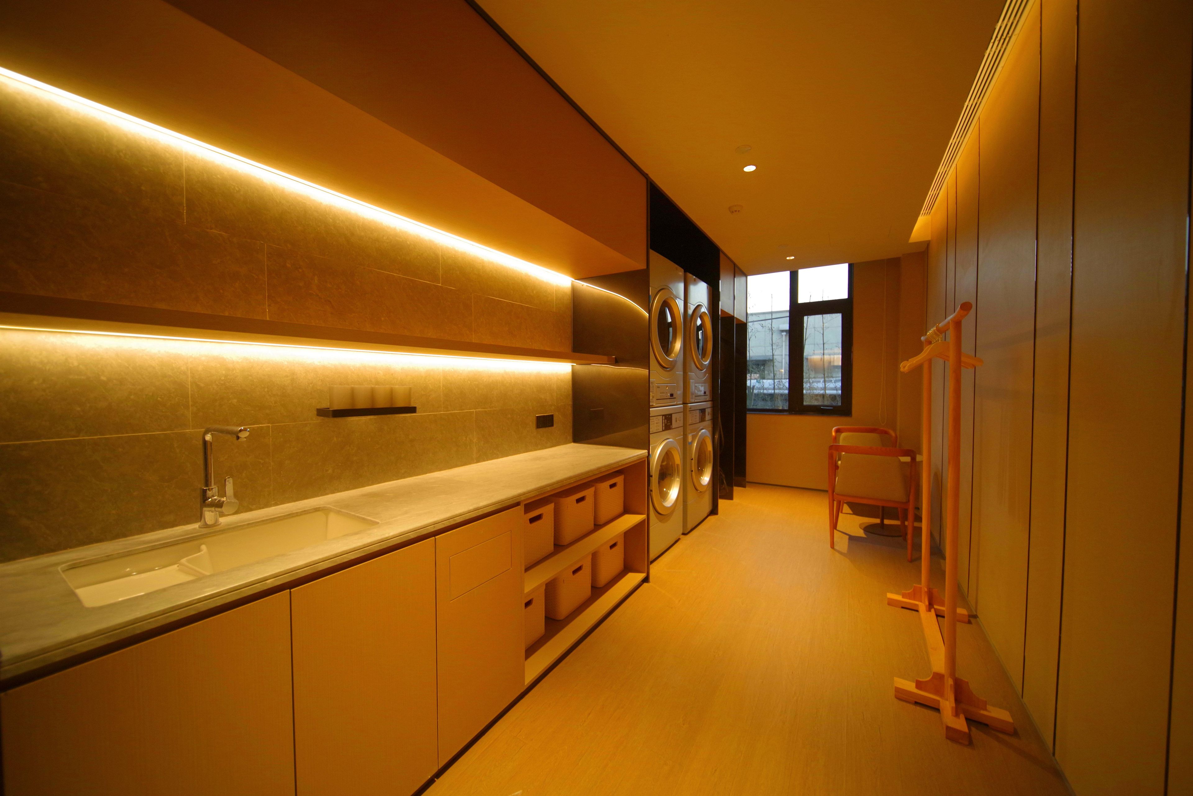 Una cocina moderna con electrodomésticos integrados, un ventanal grande y piso de madera.