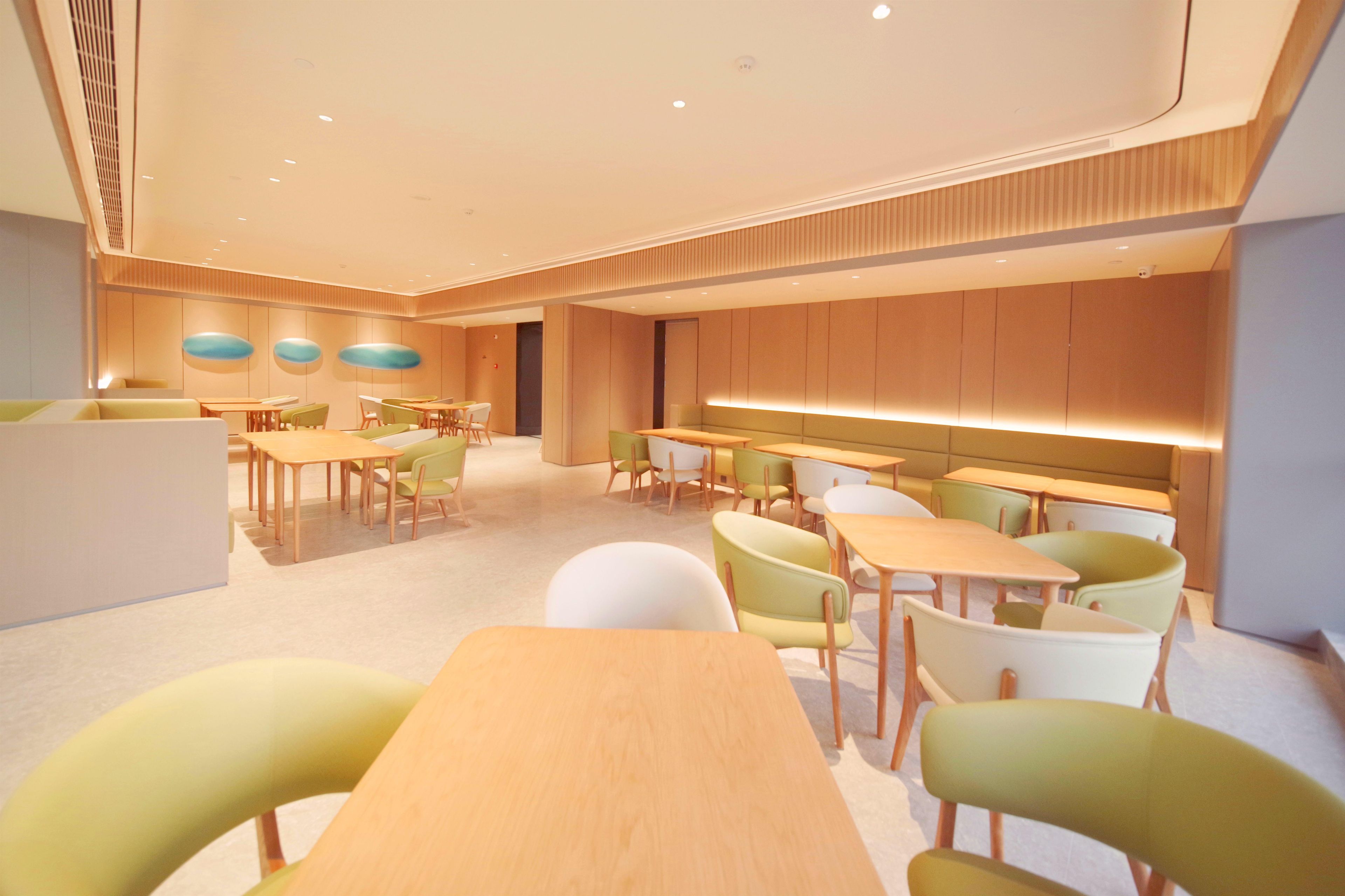 A modern interior with a central dining area, multiple seating arrangements, and a long counter.