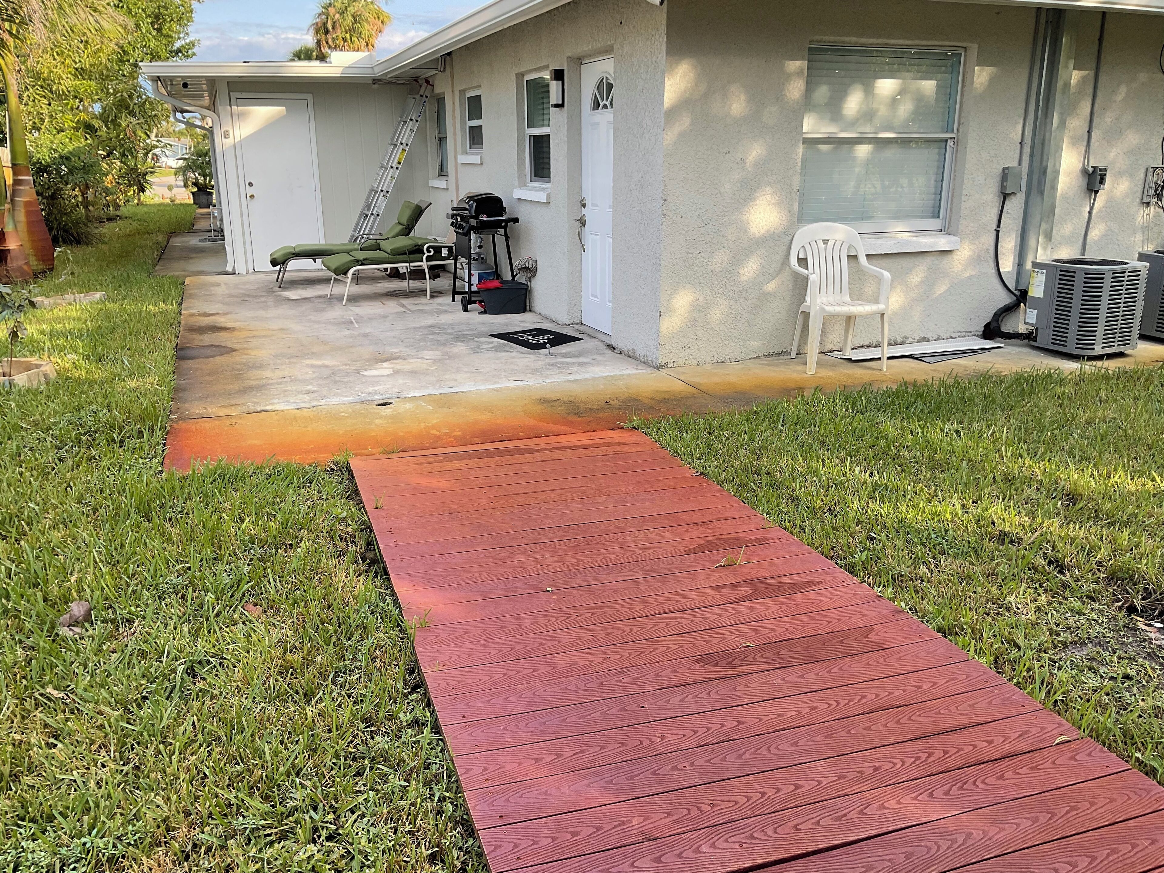 Ein Haus mit einer roten Holzdachterrasse, die zu einer Garage führt.