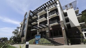 A multi-story hotel with balconies, a stone facade, and a sign reading "Lagun". - Lagun Hotel (El Nido)