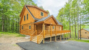 A log cabin with a front porch and a staircase leading to the entrance. - Almost Eden by Taylor Made Deep Creek (McHenry)