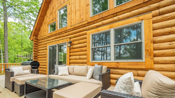 A log cabin with a deck, outdoor furniture, and a grill. - Almost Eden by Taylor Made Deep Creek (McHenry)