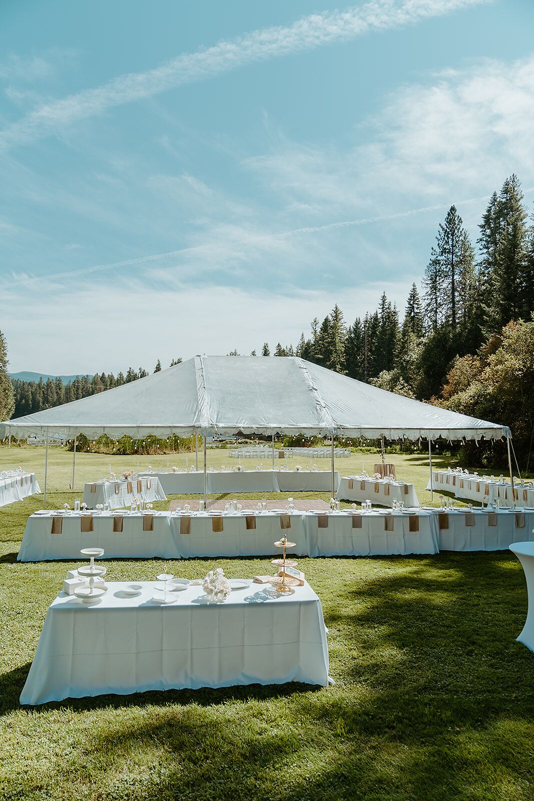 A tented outdoor event space with tables set for a reception.