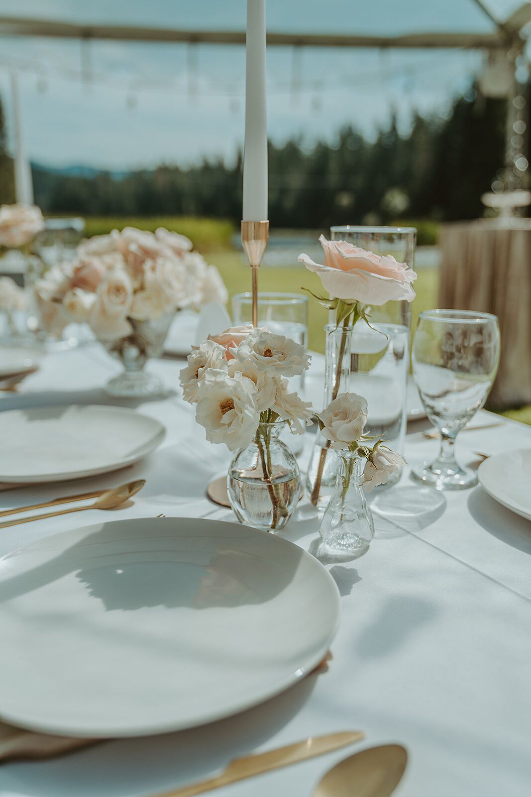 A table set for a meal with white plates, glasses, and cutlery.